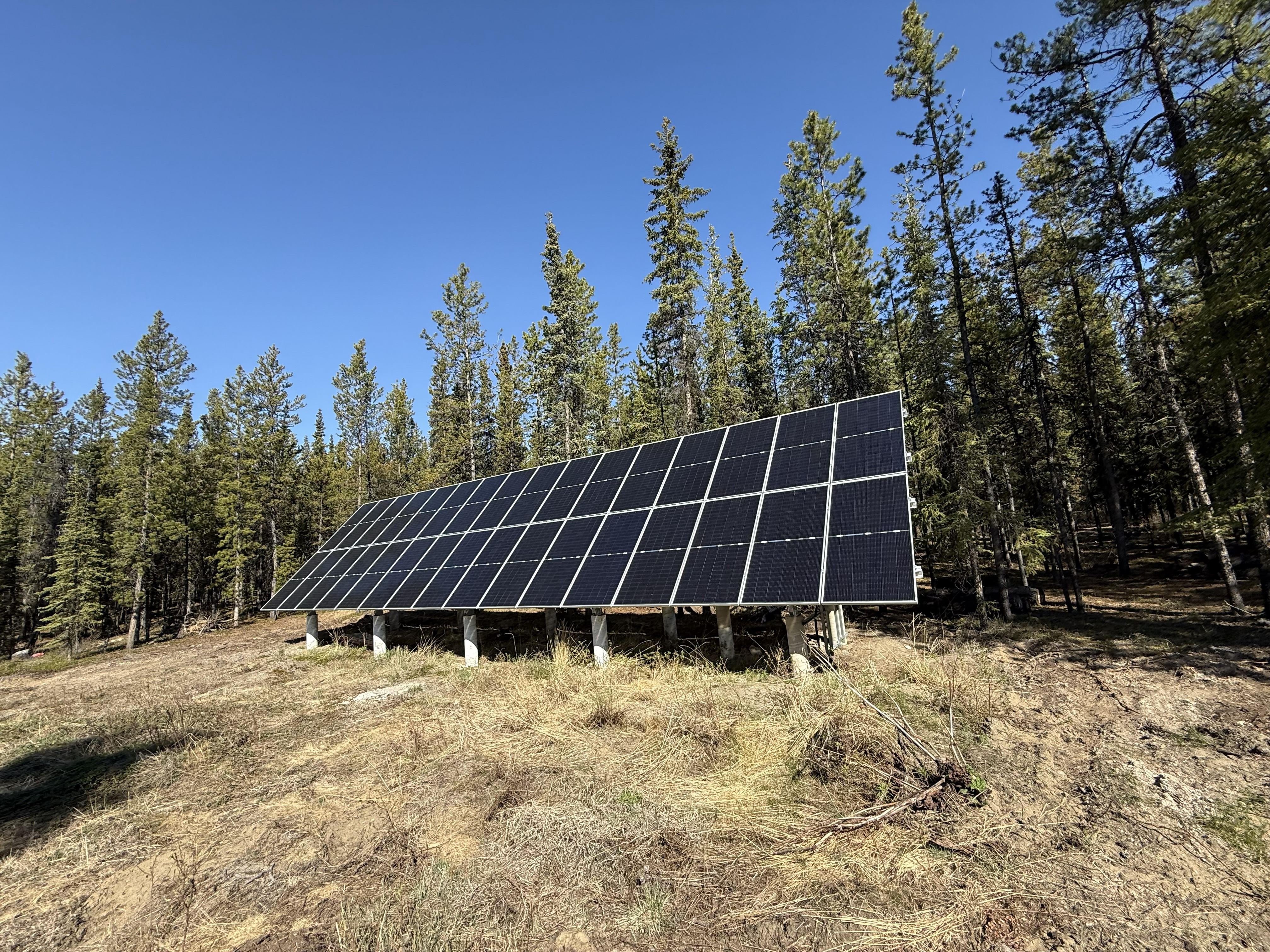 Solar panel installation with Yukon mountain and lake backdrop